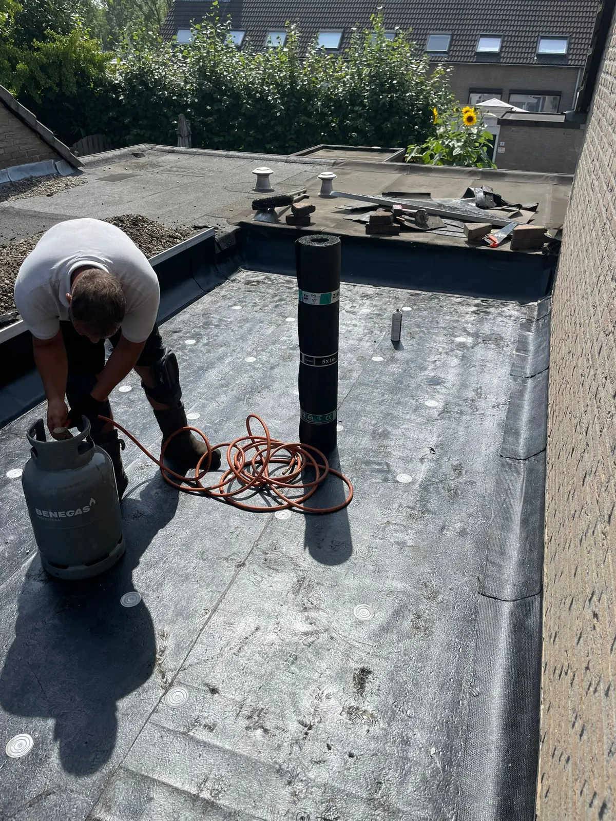 Dakdekker brandt nieuwe bitumen op een plat dak
