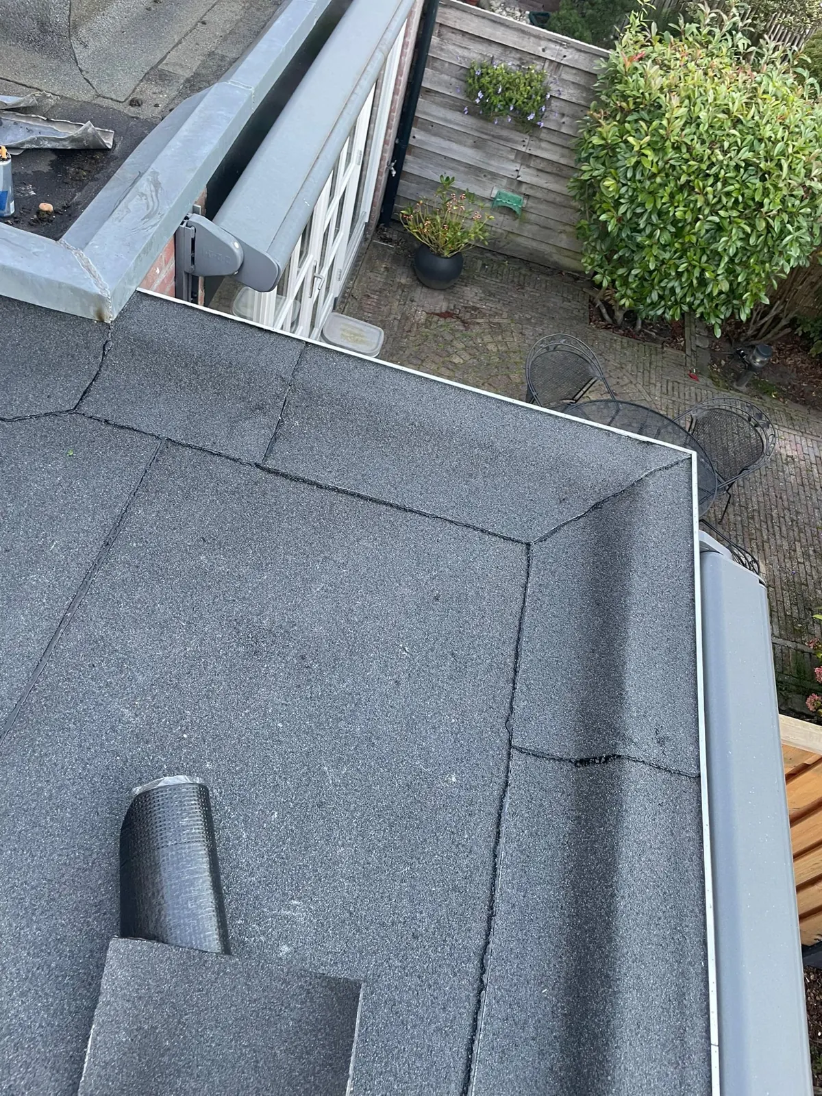 Afgewerkte dakrand van een plat dak met bitumen